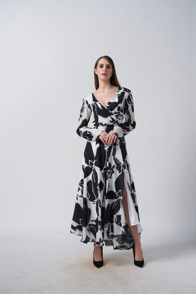 Model facing front in black and white floral crepe dress with V-neck and long sleeves.