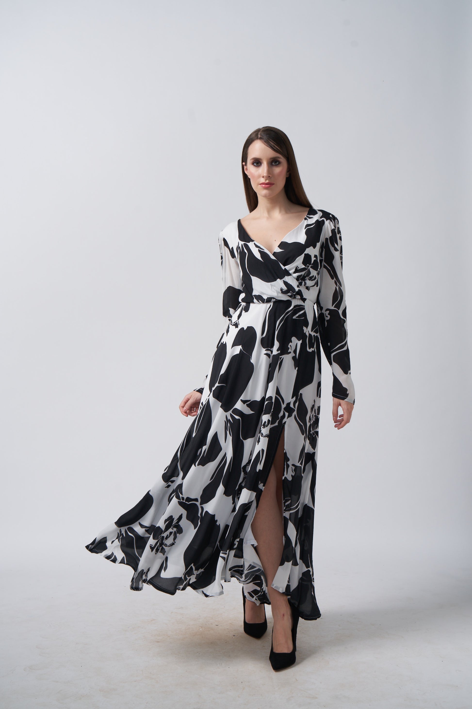 Model twirling to display the full flow and silhouette of the black and white crepe dress.
