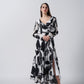 Long-sleeved maxi dress featuring a plunging V-neckline and a wrap-style bodice, showcasing a bold black and white floral print.
