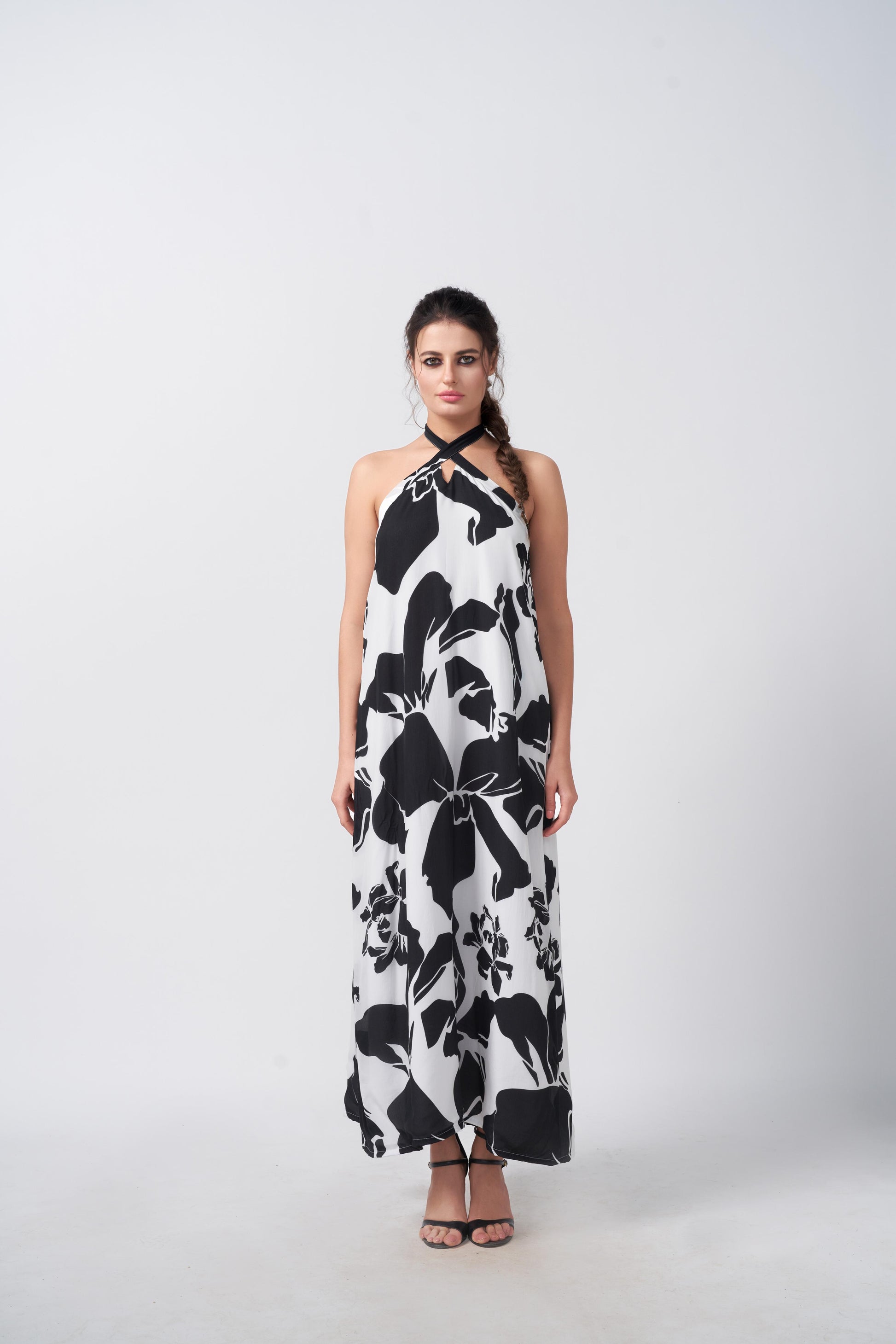 Model standing front-facing in black and white abstract floral halter dress, highlighting the ankle-length silhouette.