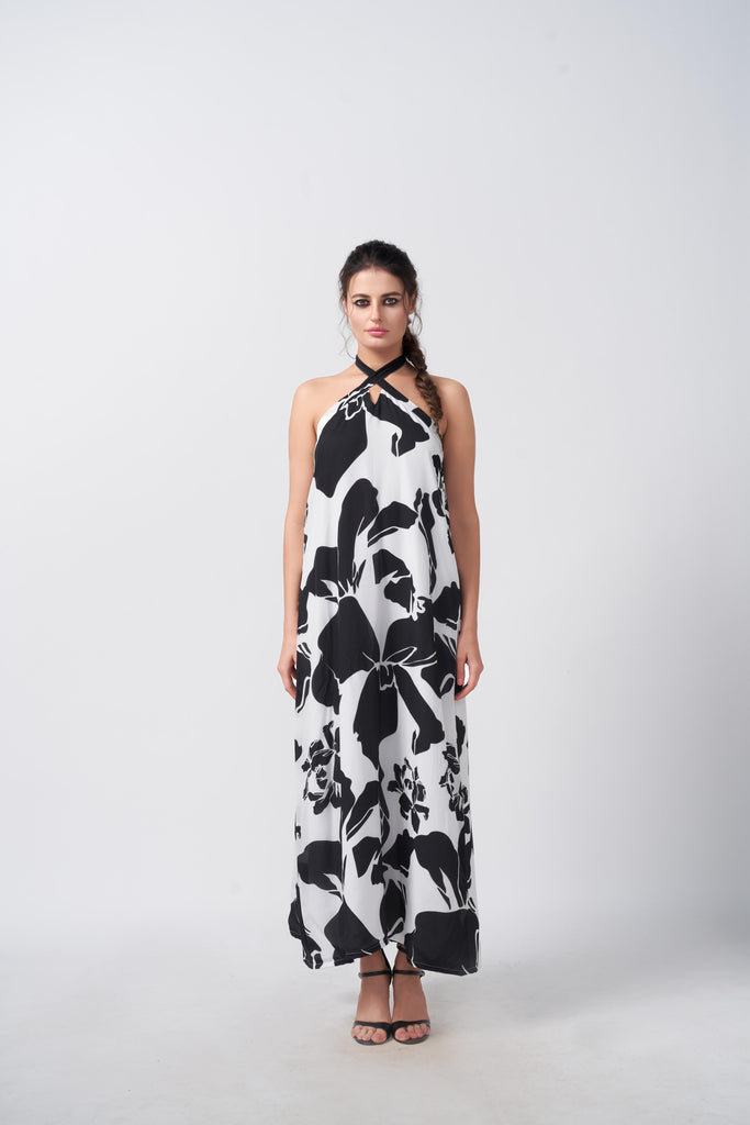 Model standing front-facing in black and white abstract floral halter dress, highlighting the ankle-length silhouette.