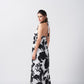 Side view of the model in black and white floral dress, showcasing the flow and tie-back halter neck.