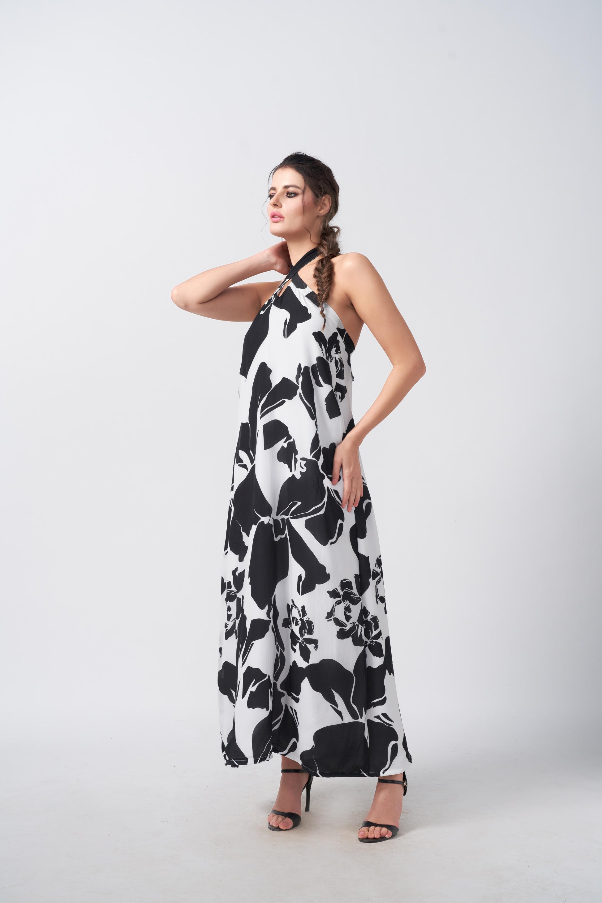 Model posing with hand on waist in black and white halter dress, showing the confident fit and fluid cut.