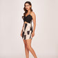 Model in a black and white printed silk mini dress with sweetheart ruched neckline and spaghetti straps, standing front-facing.