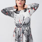  Model with arms raised, highlighting the bateau neckline and knot detail of the floral satin dress.