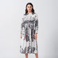 Full front view of model in a white and grey floral midi dress with long sleeves and a round neckline.