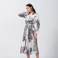 Model in a satin midi dress turning sideways, showcasing the soft drape and sleeve length.