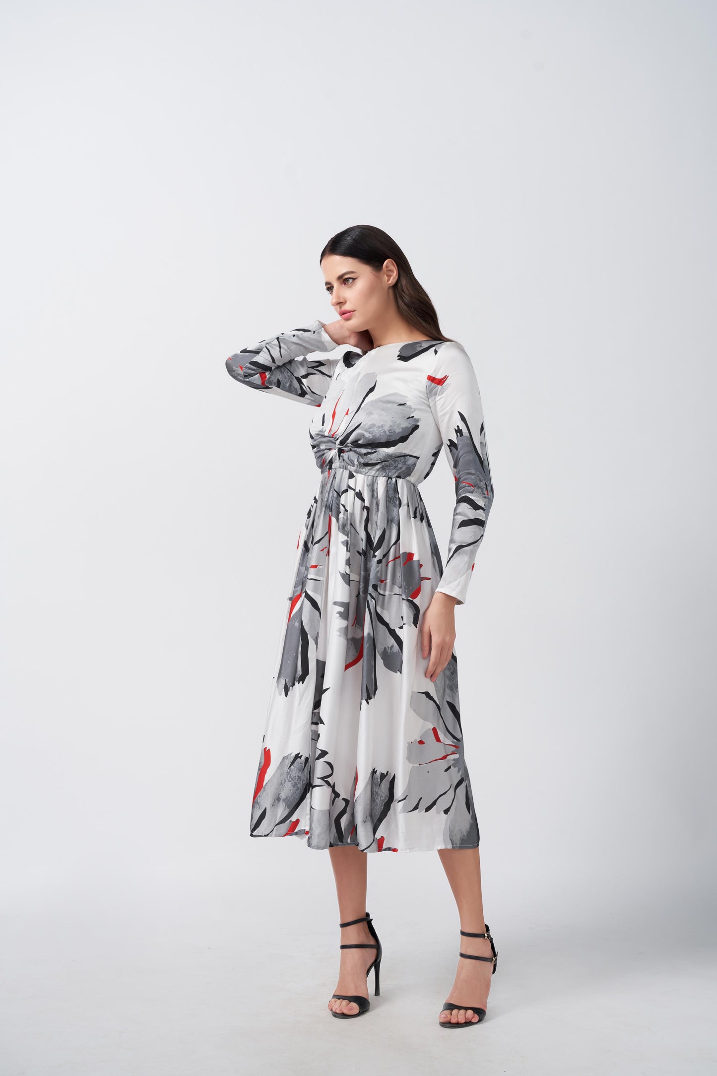 Model in a satin midi dress turning sideways, showcasing the soft drape and sleeve length.