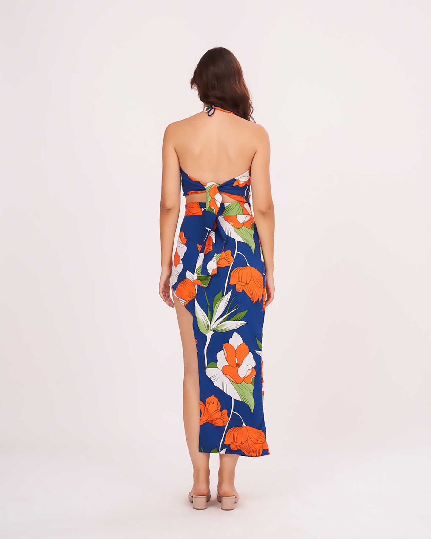Rear view of the blue co-ord set with open back halter neck and skirt showcasing the back tie-up closure and vibrant floral pattern.