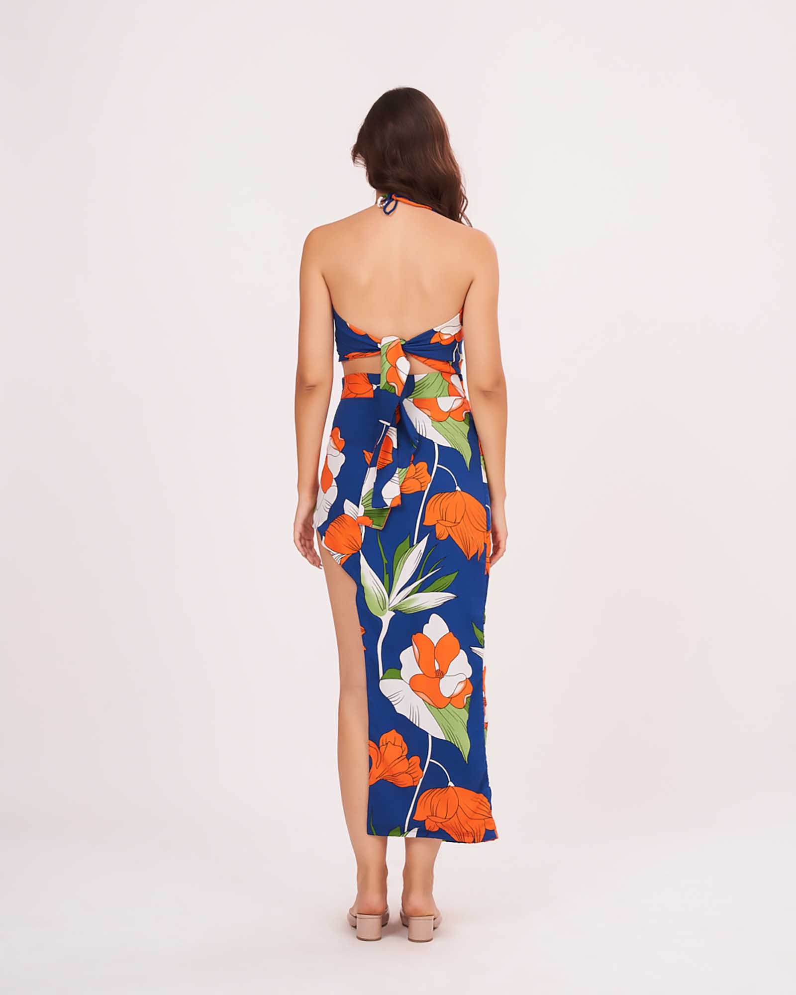 Rear view of the blue co-ord set with open back halter neck and skirt showcasing the back tie-up closure and vibrant floral pattern.