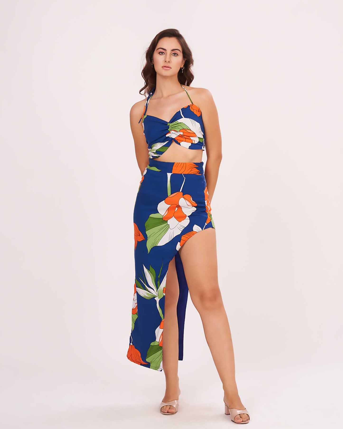 Model in a confident standing pose wearing the blue floral co-ord set with halter neck and asymmetric slit skirt, highlighting the front silhouette.