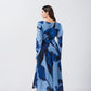 Back view of the model in blue floral dress, showcasing flowy silhouette and full sleeve coverage.
