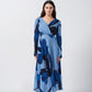 Model standing front-facing in light and dark blue floral crepe dress with overlap V-neck and long sleeves.