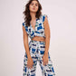 Model  wearing the blue geometric co-ord set with sleeveless V-neck crop top and printed parallel trousers.