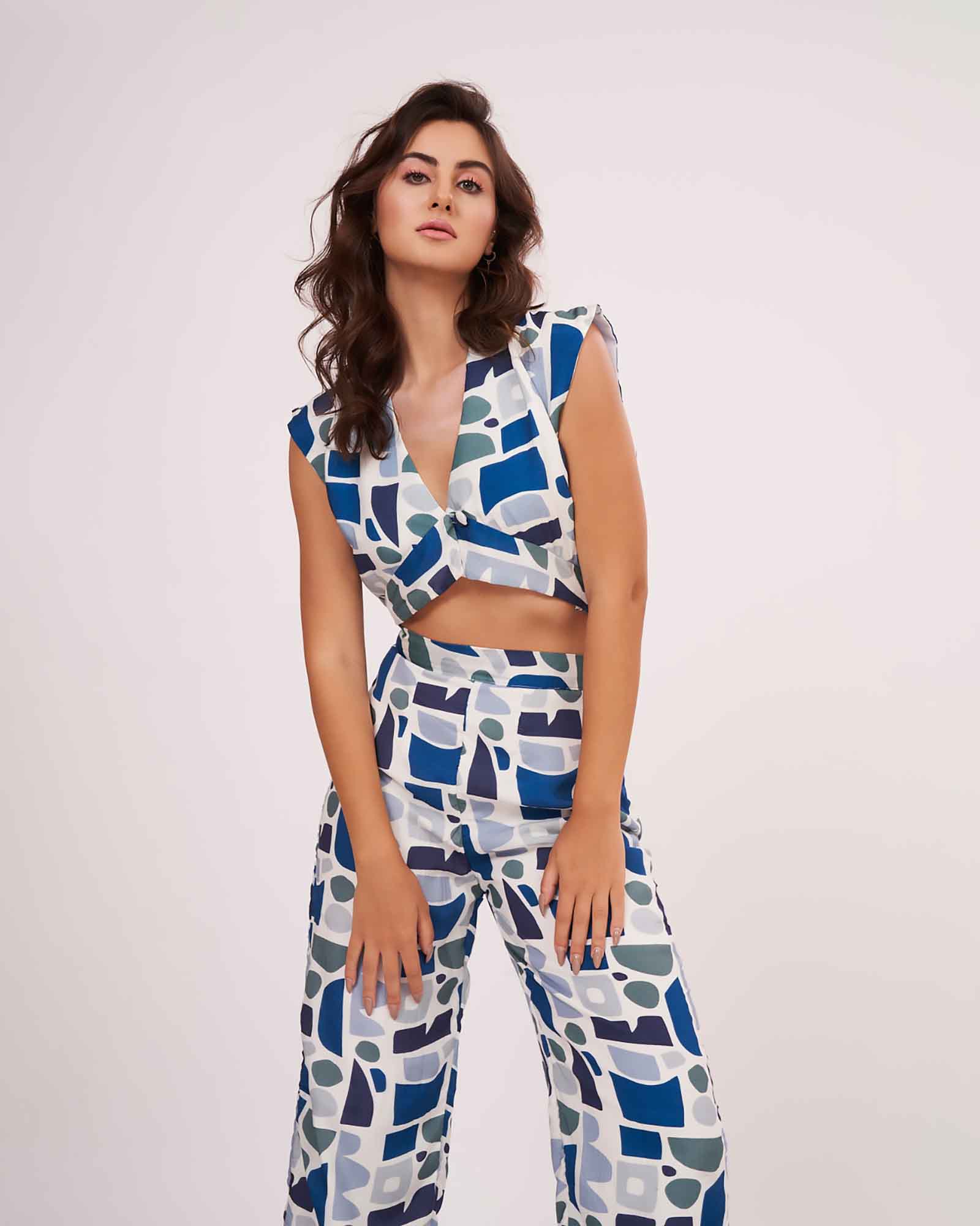 Model  wearing the blue geometric co-ord set with sleeveless V-neck crop top and printed parallel trousers.