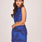 Side profile of the model in a sleeveless floral halter top and printed skirt co-ord, emphasizing waist fit and silhouette.