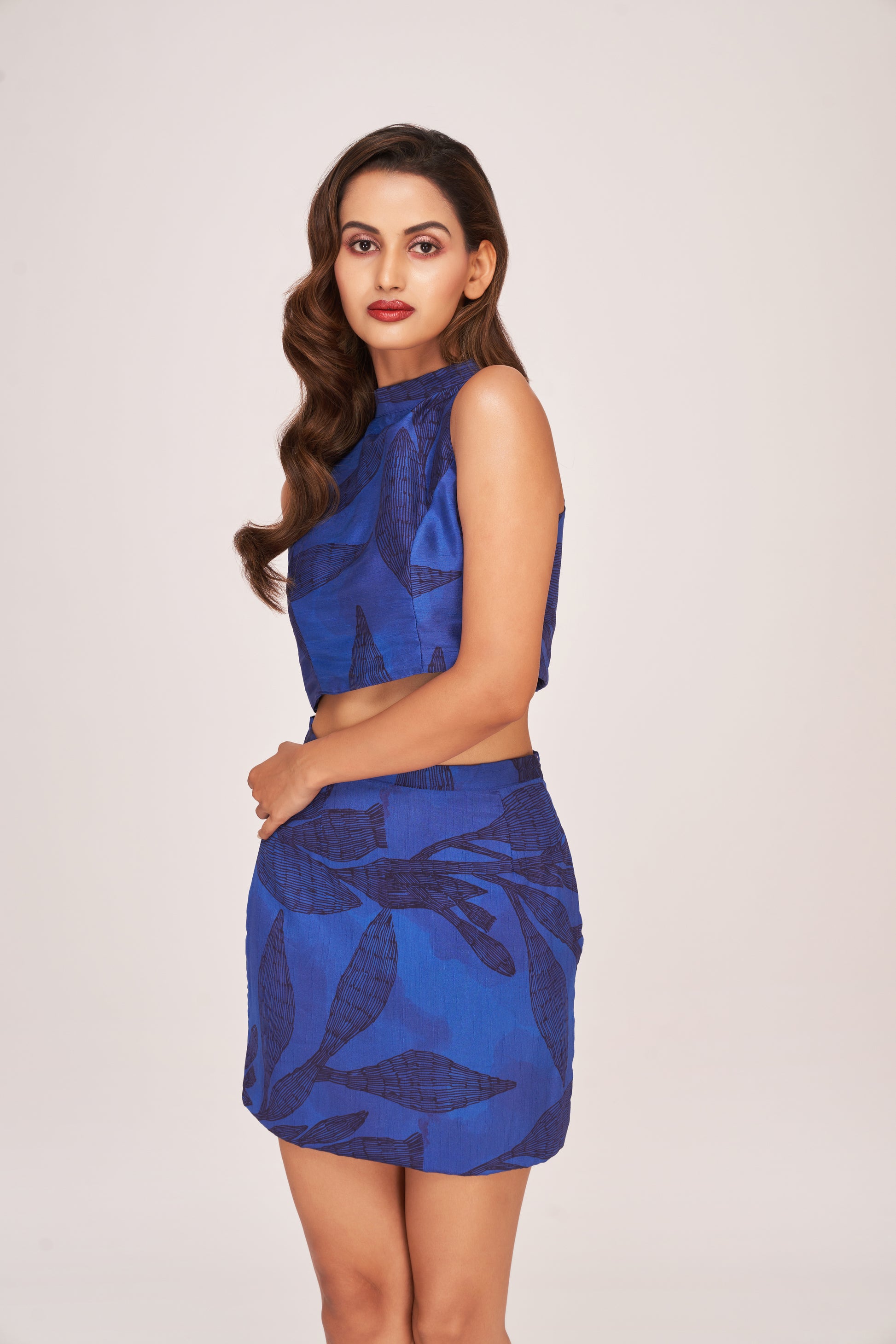 Side profile of the model in a sleeveless floral halter top and printed skirt co-ord, emphasizing waist fit and silhouette.