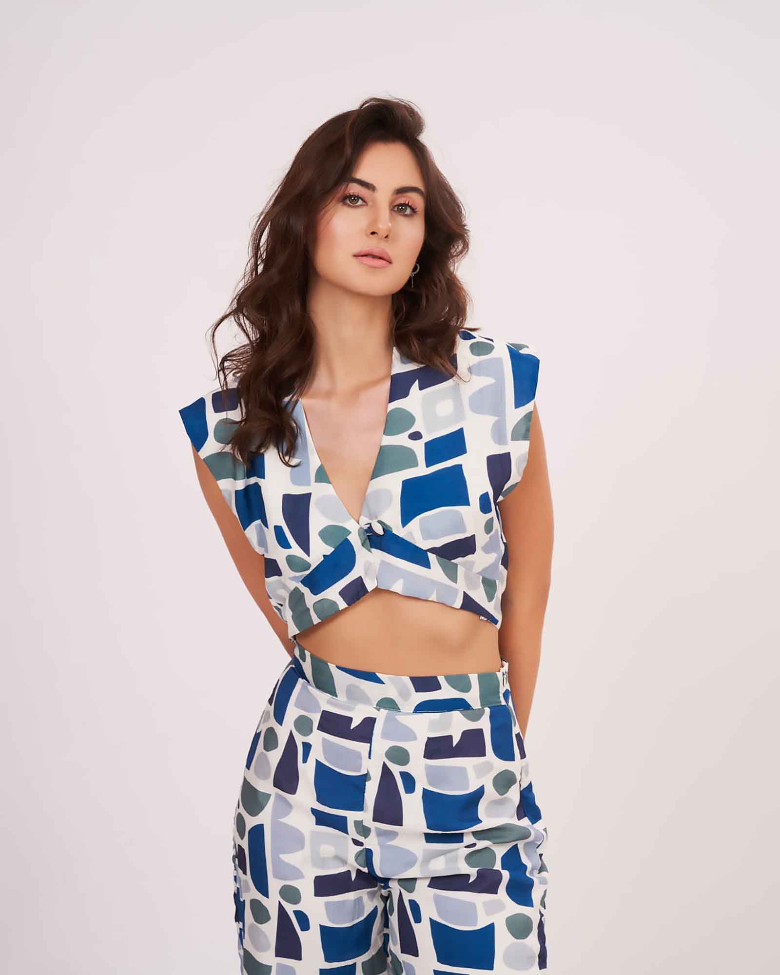 Close-to-front angled pose highlighting the geometric design of the blue co-ord set with a flattering parallel pant silhouette.