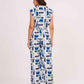 Rear view of the blue V-neck crop top and matching printed trousers, highlighting the back button and relaxed straight-leg pant fit.
