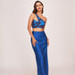 Full frontal pose of model in printed one-shoulder blue co-ord set with a side slit skirt and pleated detail.