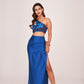 Model standing straight in a satin blue co-ord set, showcasing the thigh-high slit and one-shoulder printed crop top.
