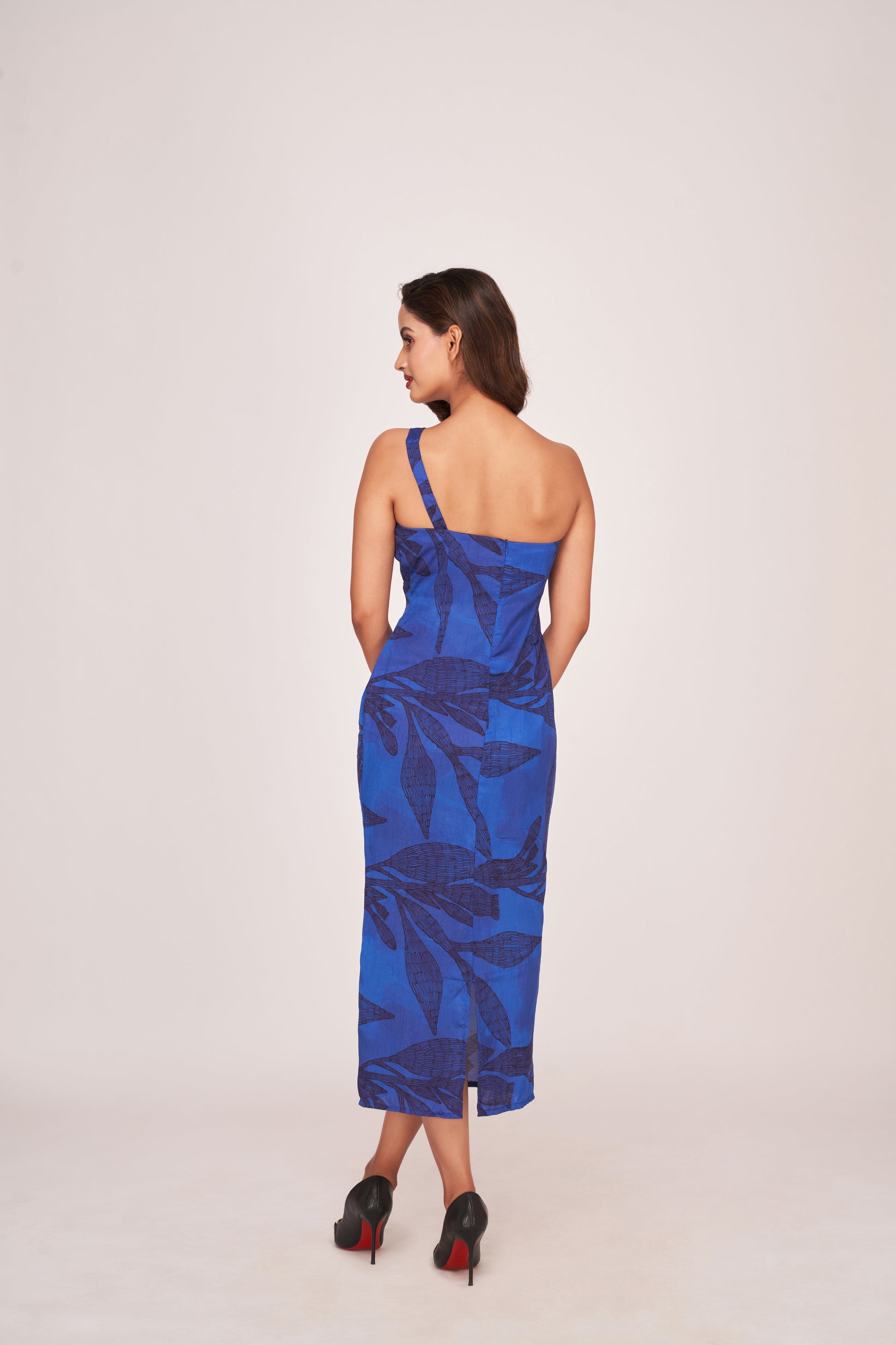 Back view of a blue silk one-shoulder dress with a back zip closure and clean silhouette