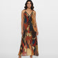 Full-length maxi dress featuring a deep V-neckline with a contrasting geometric-patterned border and halter neckline.