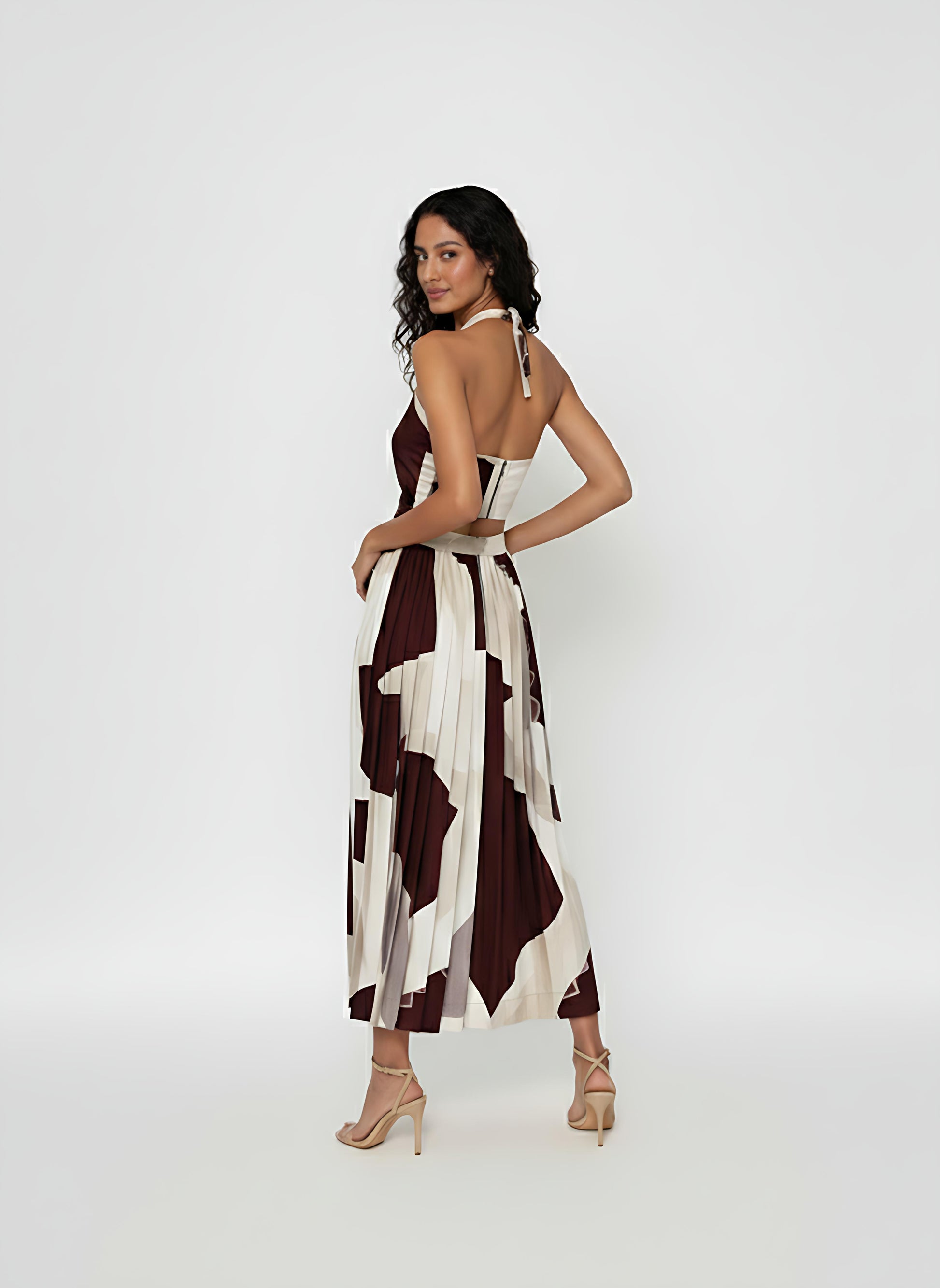 Open-back silhouette with an adjustable self-tie neck fastening and a structured waistband, ideal for upscale resort wear or summer evening events.