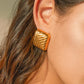 These striking gold geometric earrings offer a modern and architectural look that sits elegantly on the lobe, making them an ideal statement accessory for a gallery opening or a minimalist dinner outfit.