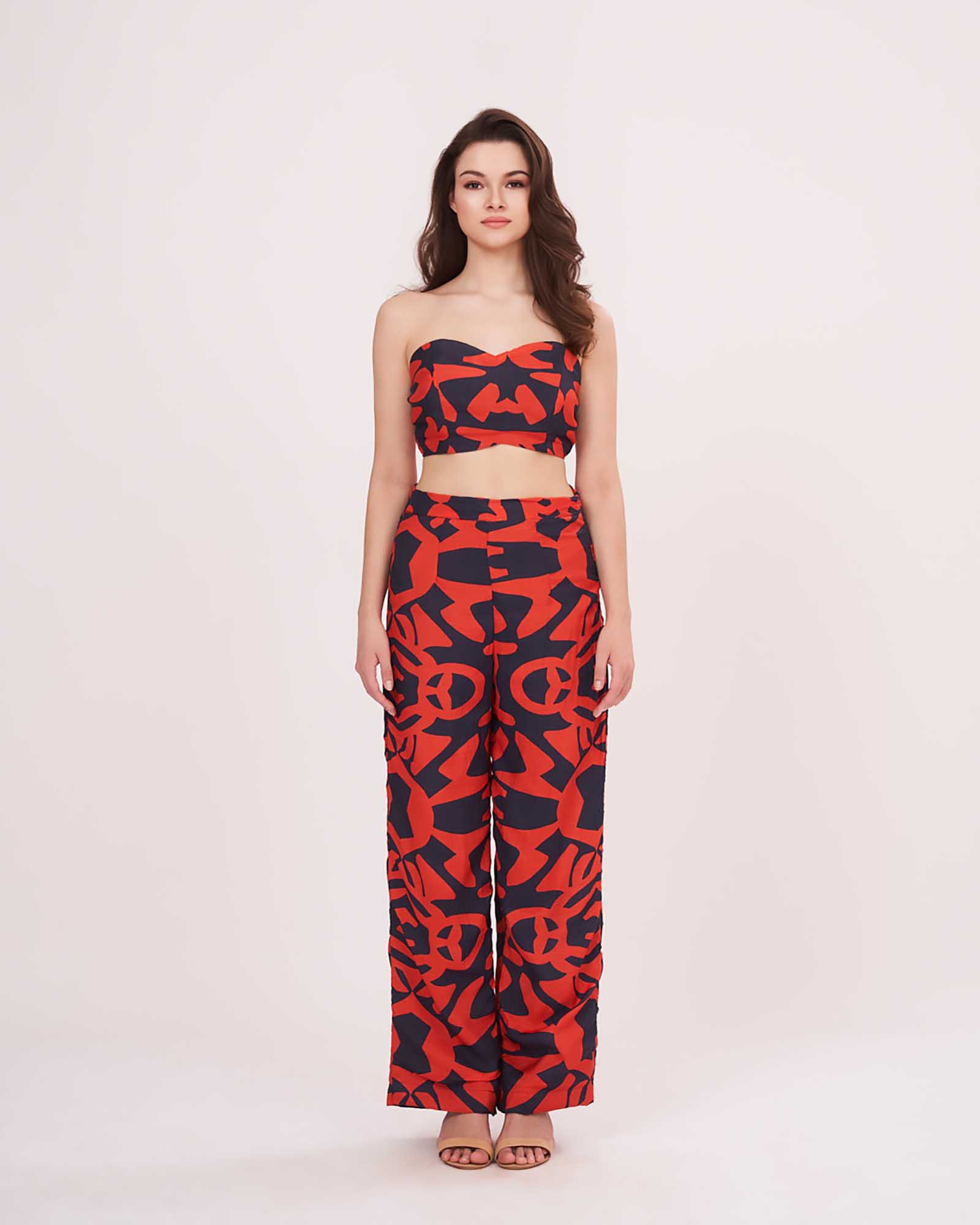 Model stands tall in colorful co-ord set with fitted V-neck crop top and relaxed parallel pants, showing a full front profile.