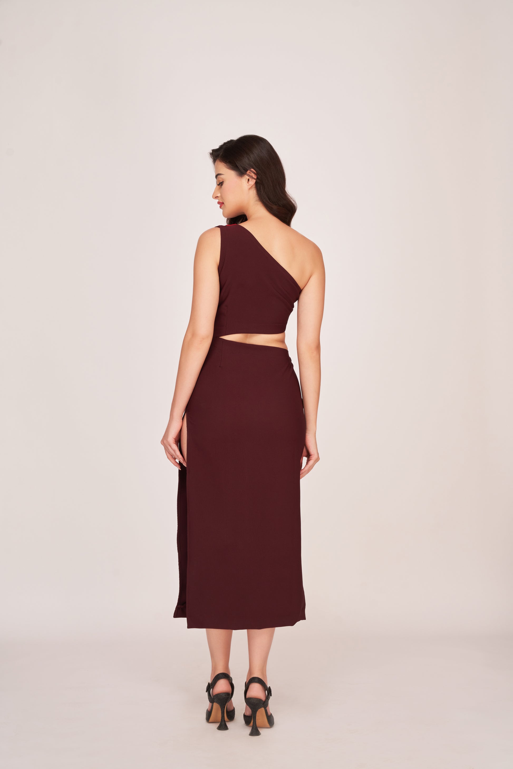 Rear view of the dress showing one-shoulder strap and back zip closure, with full-length silhouette visible.