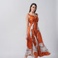 Model mid-walk in burnt orange and white midi dress, highlighting fabric movement and flattering silhouette.