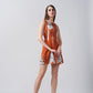 Model walking forward in a short burnt orange and white abstract dress with a modern silhouette.