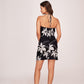 Back view   of model in black satin mini dress with cowl neck, showcasing neckline and floral pattern.