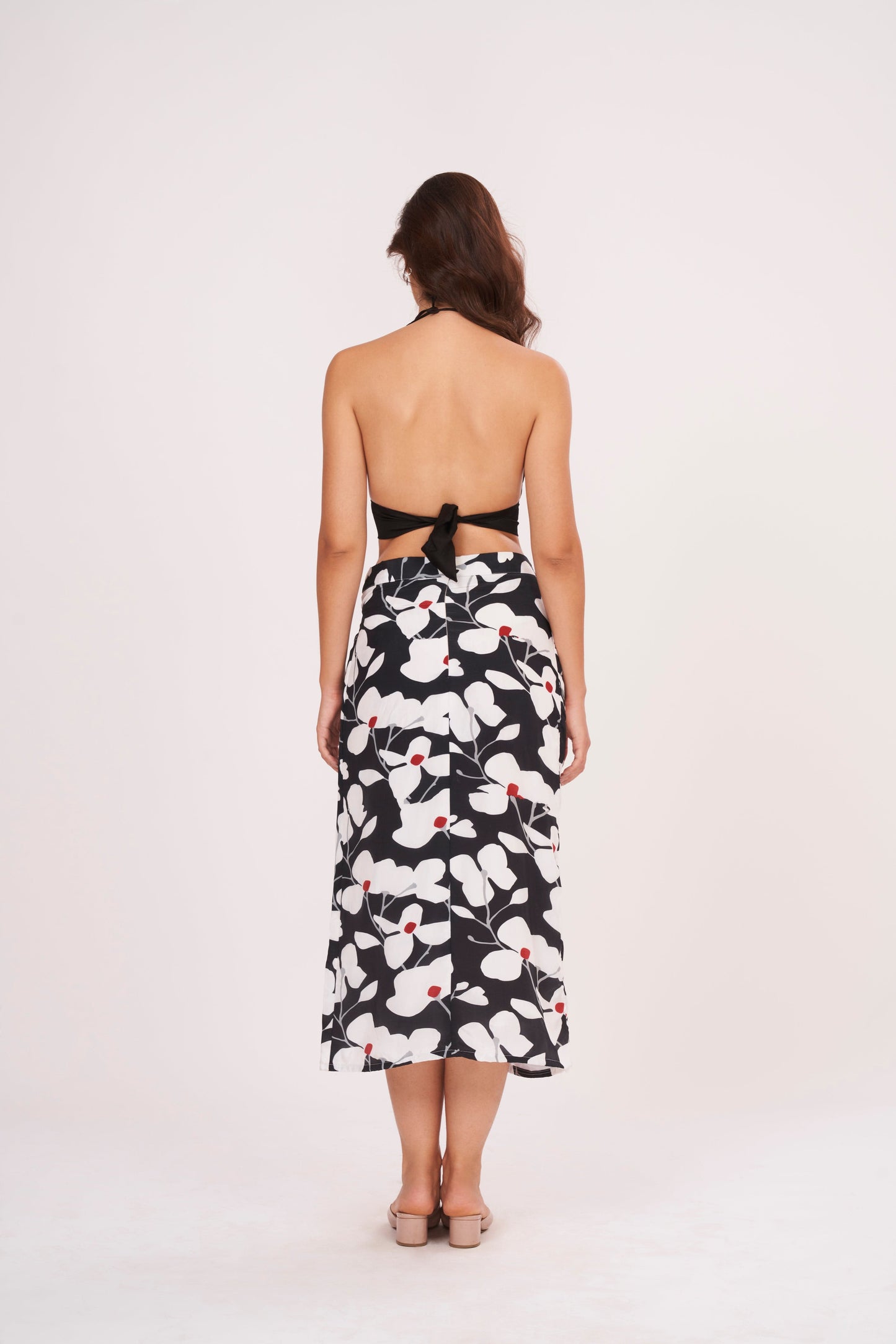 Open back bodice design with a secure tie-up knot detail and a straight-cut printed midi skirt.