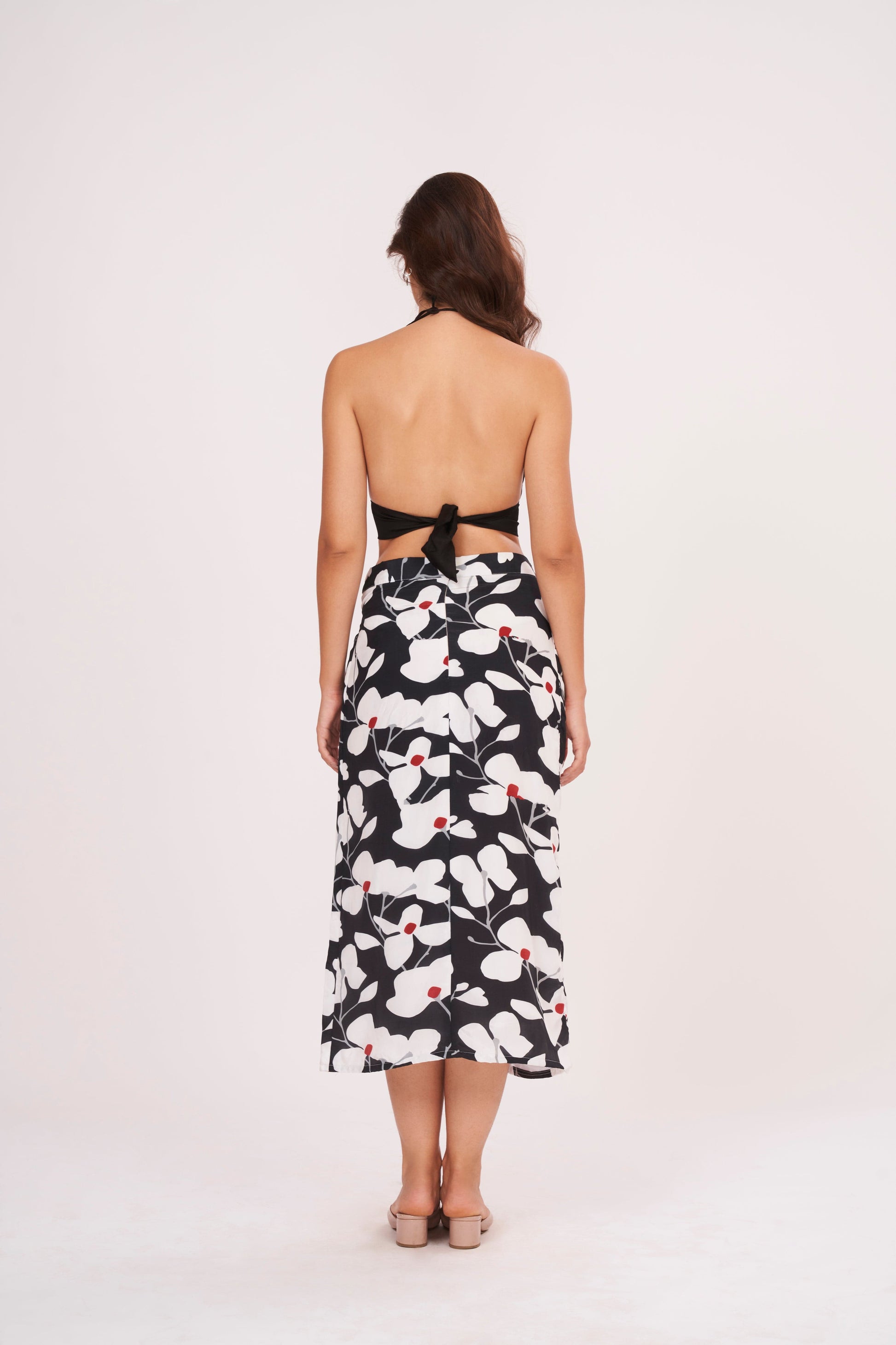 Open back bodice design with a secure tie-up knot detail and a straight-cut printed midi skirt.