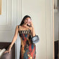 Full-length sleeveless maxi dress featuring a bold, abstract geometric print in a warm palette of rust, brown, and deep blue tones.