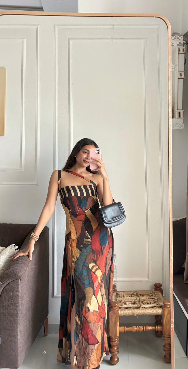 Full-length sleeveless maxi dress featuring a bold, abstract geometric print in a warm palette of rust, brown, and deep blue tones.