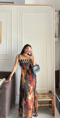 Full-length sleeveless maxi dress featuring a bold, abstract geometric print in a warm palette of rust, brown, and deep blue tones.