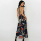 Backless silhouette featuring a distinctive long black and white striped neck tie that drapes down the center back, contrasting with the multi-colored print.