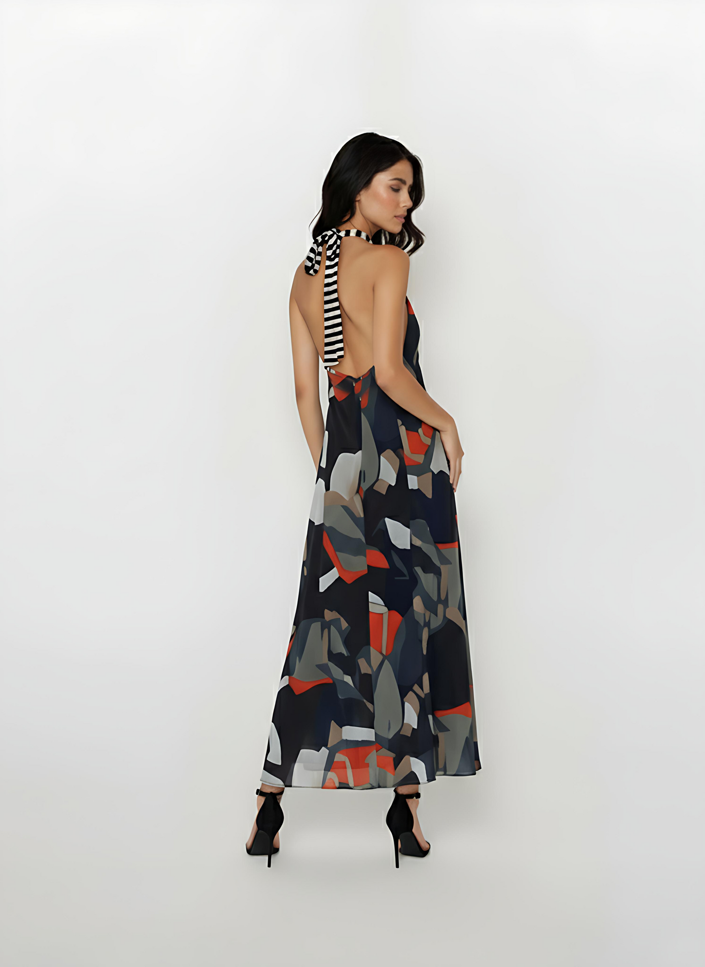 Backless silhouette featuring a distinctive long black and white striped neck tie that drapes down the center back, contrasting with the multi-colored print.