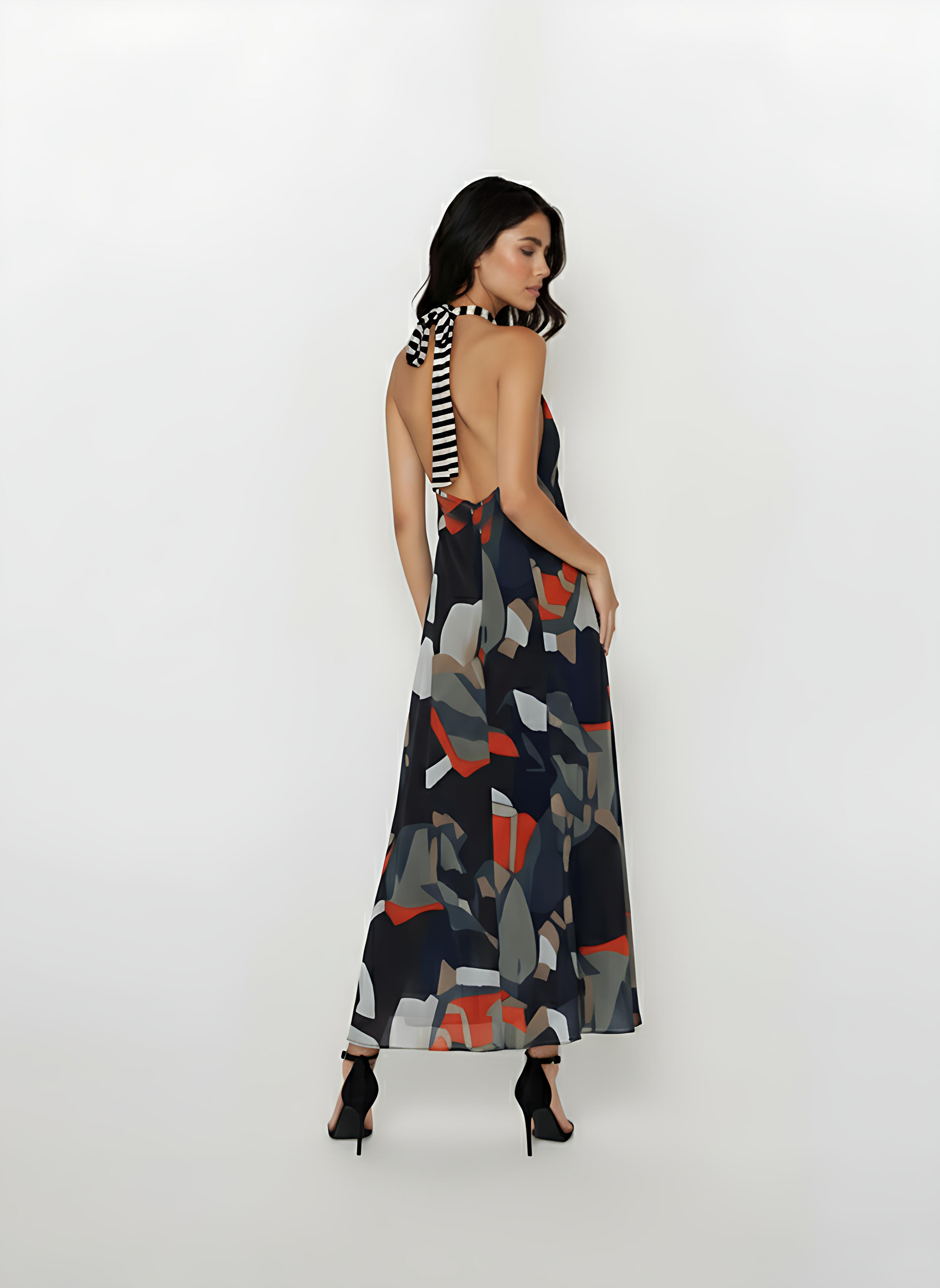 Backless silhouette featuring a distinctive long black and white striped neck tie that drapes down the center back, contrasting with the multi-colored print.