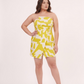 Close-up of elasticated tube neckline with cut accents on a lime yellow geometric muslin midi dress