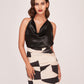 Full-length view of the two-piece set, combining a solid black top with an abstract printed skirt. 