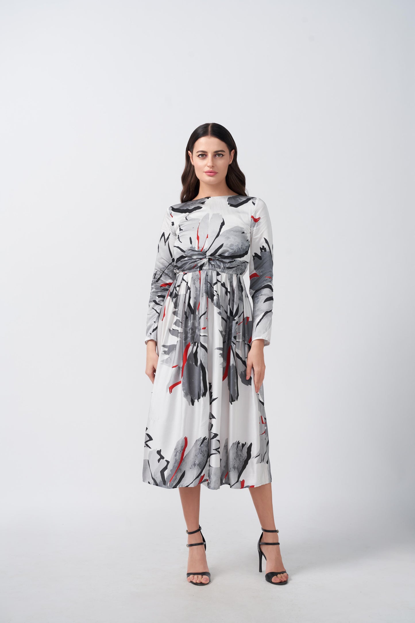 A midi-length dress showcasing a sophisticated white and grey abstract floral print with warm red accents, finished with long sleeves for a polished look.