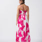Back view of an ankle-length crepe dress with spaghetti straps and a flowing gathered silhouette