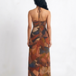 Gracefully draped Chinon maxi dress with an open-back halter design and warm-toned abstract print for a timeless, effortlessly elegant look.