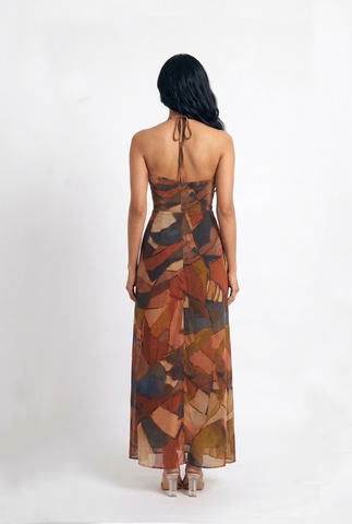 Gracefully draped Chinon maxi dress with an open-back halter design and warm-toned abstract print for a timeless, effortlessly elegant look.