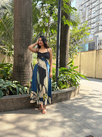 Long, airy dress with a structured halter bodice that transitions into a voluminous, floor-grazing skirt. The play of light on the lightweight material emphasizes the depth of the dark green and slate accents, ideal for transitioning from a sunlit afternoon to an evening event.
