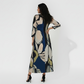 Ankle-length dress with a high, closed back and long fitted sleeves that emphasize a streamlined silhouette. The continuous abstract pattern flows across the entire back of the garment.
